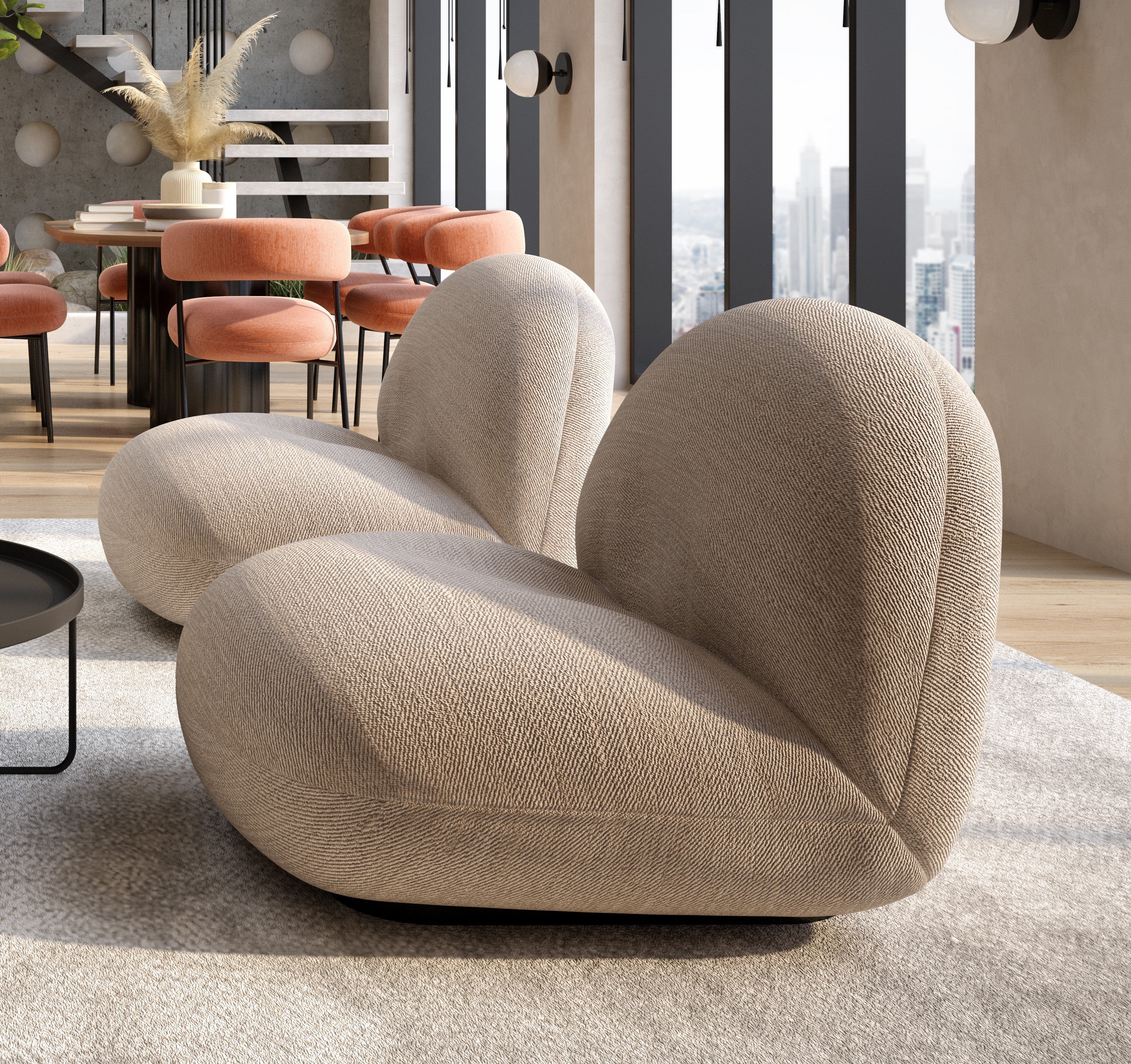 Curved, modern beige sofa with soft textured fabric in a stylish, sunlit living room. Large windows and city skyline frame the Hibiscus Lounge Chair, blending elegantly with commercial and residential seating in the contemporary décor.