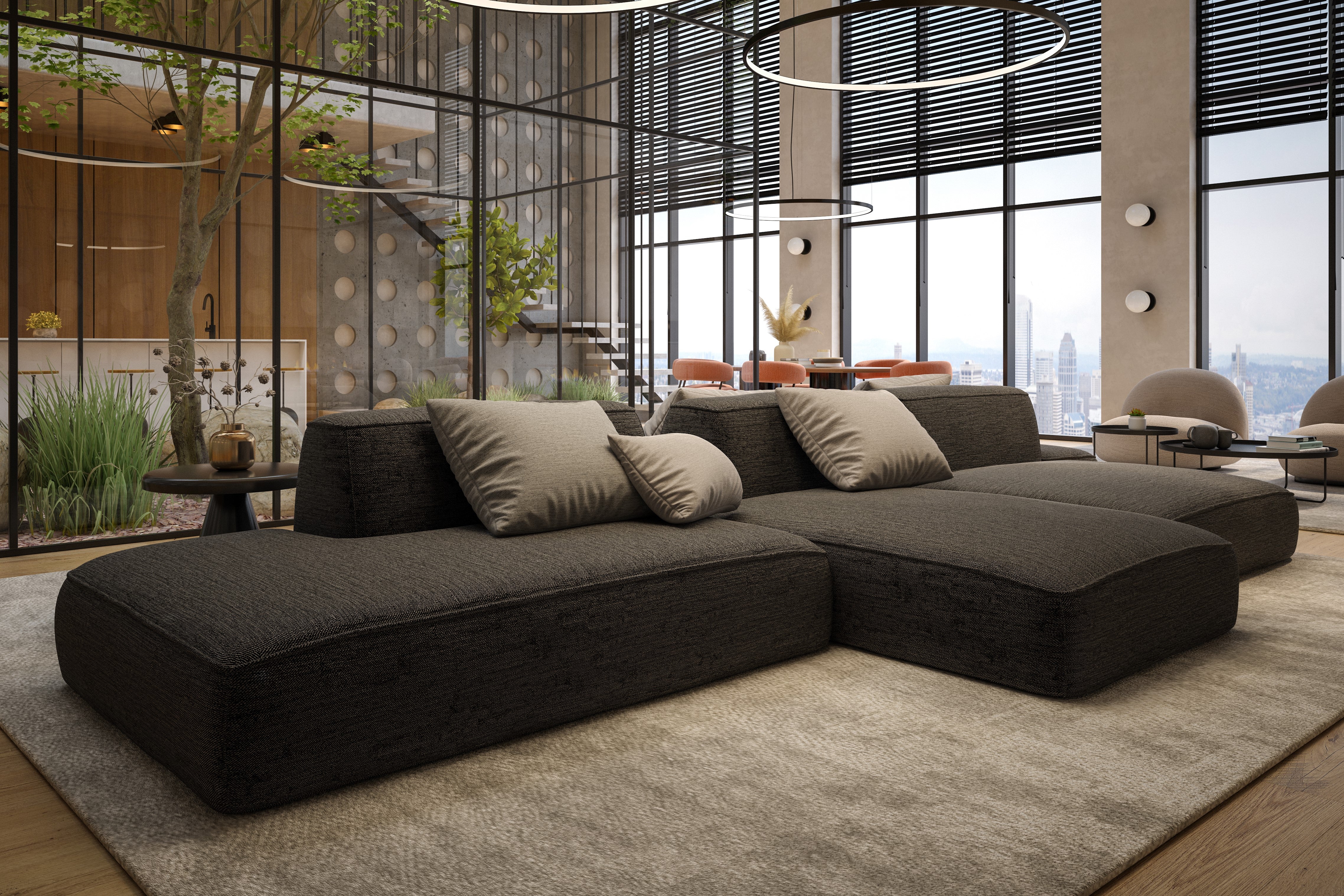 A modern living room featuring the Ivy Sectional, neutral pillows, circular hanging lights, floor-to-ceiling windows, indoor plants, and a cityscape view. The space is open and tastefully styled with contemporary furniture.