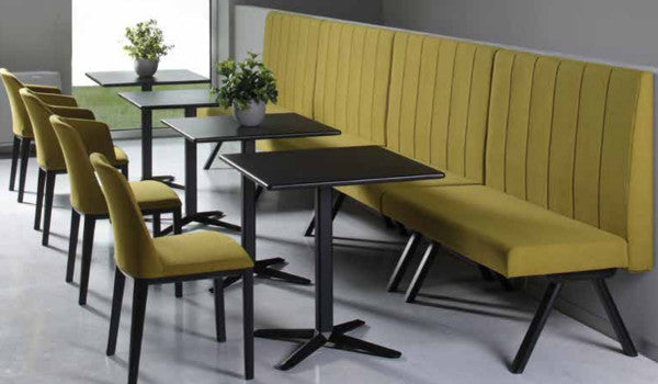Black metal tables accented by black and yellow upholstered furniture.
